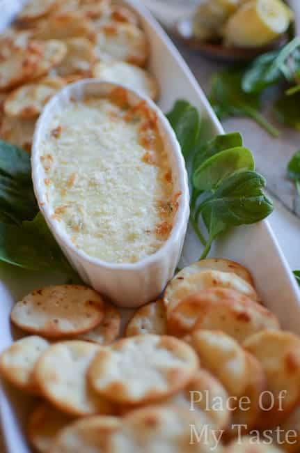 spinach and Artichoke dip on a plate with crackers