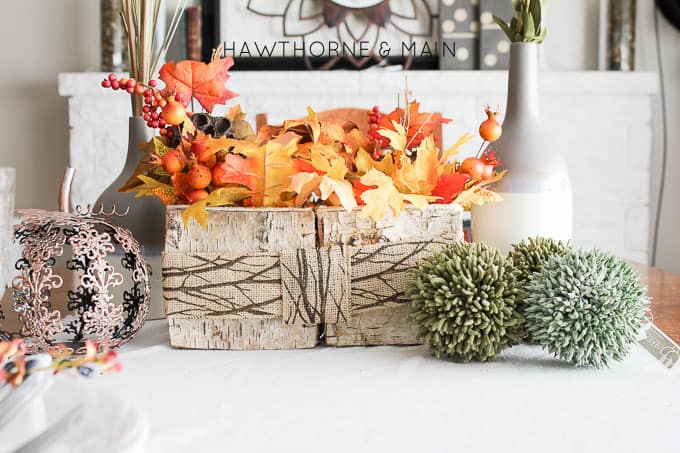 fall leaf centerpiece with burlap ribbon on the table.