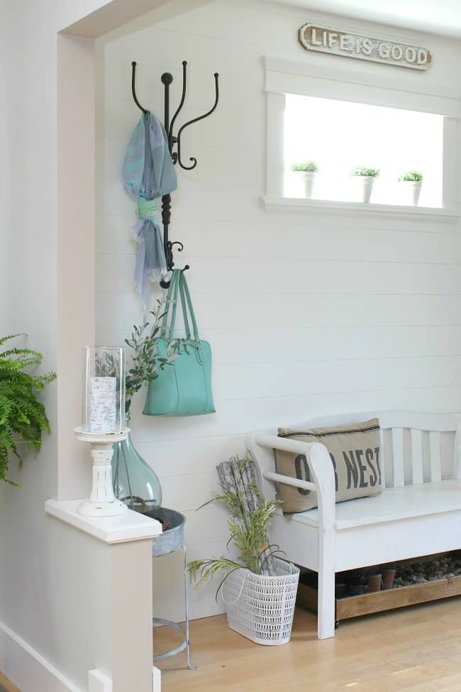 Wrought iron hooks beside the front door with a purse and a scarf on it.