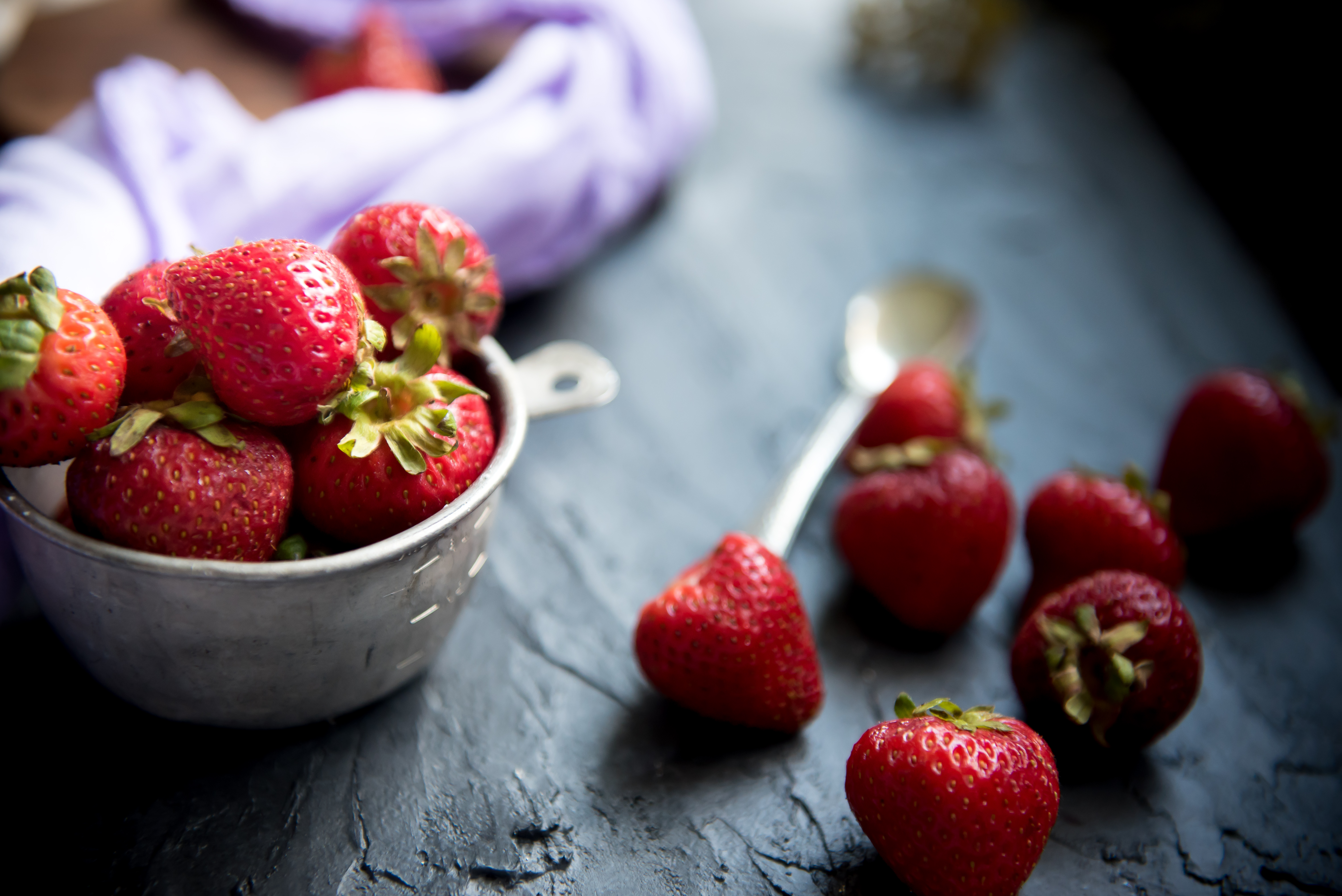 Strawberries styled with dark food photography backdrops.