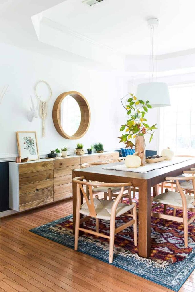 dining room with reclaimed wood buffet and large wood table- fresh branches and white pumpkinson the centerpeice