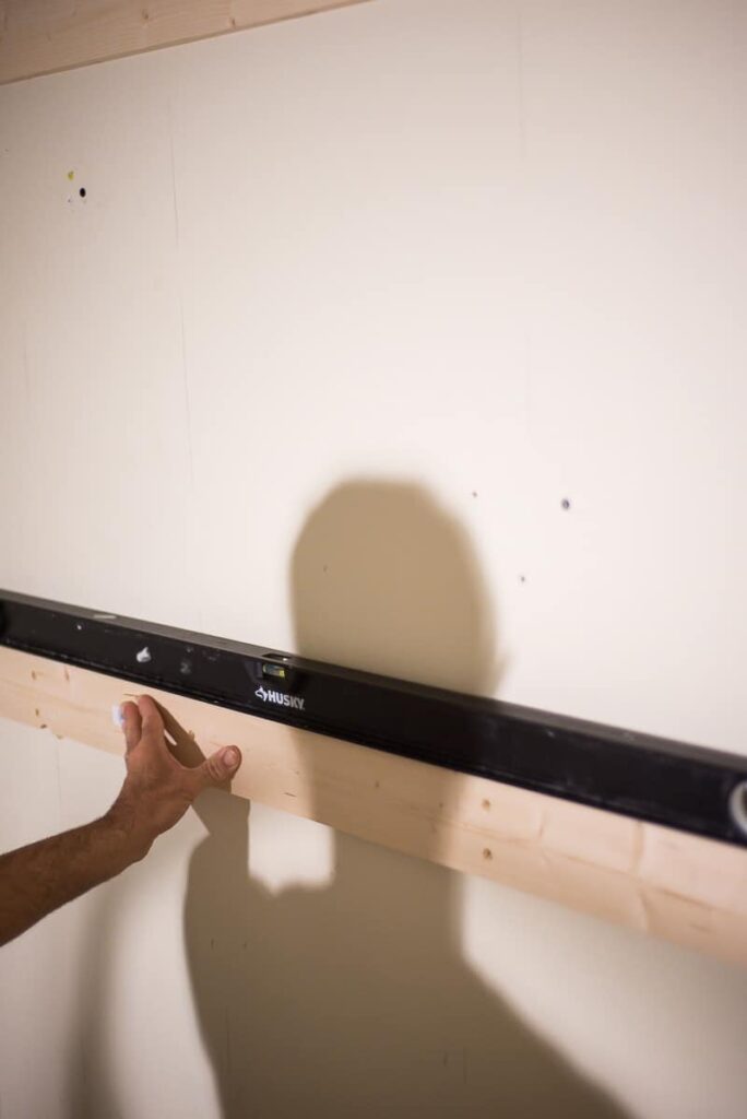 leveling the 2x4s on the wall to screw to studs