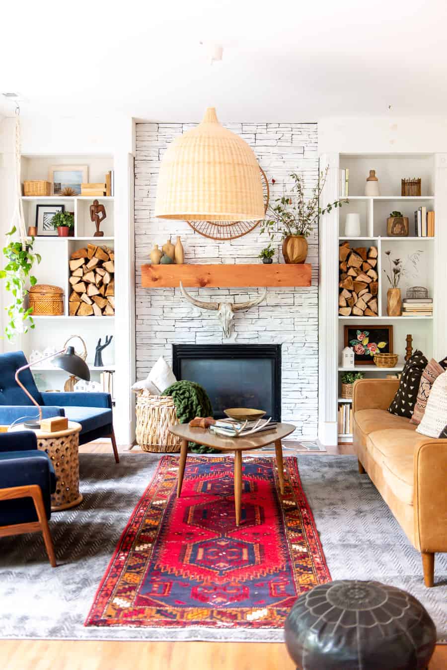 Eclectic living room decor with blue chairs, wood logs and lots of textures