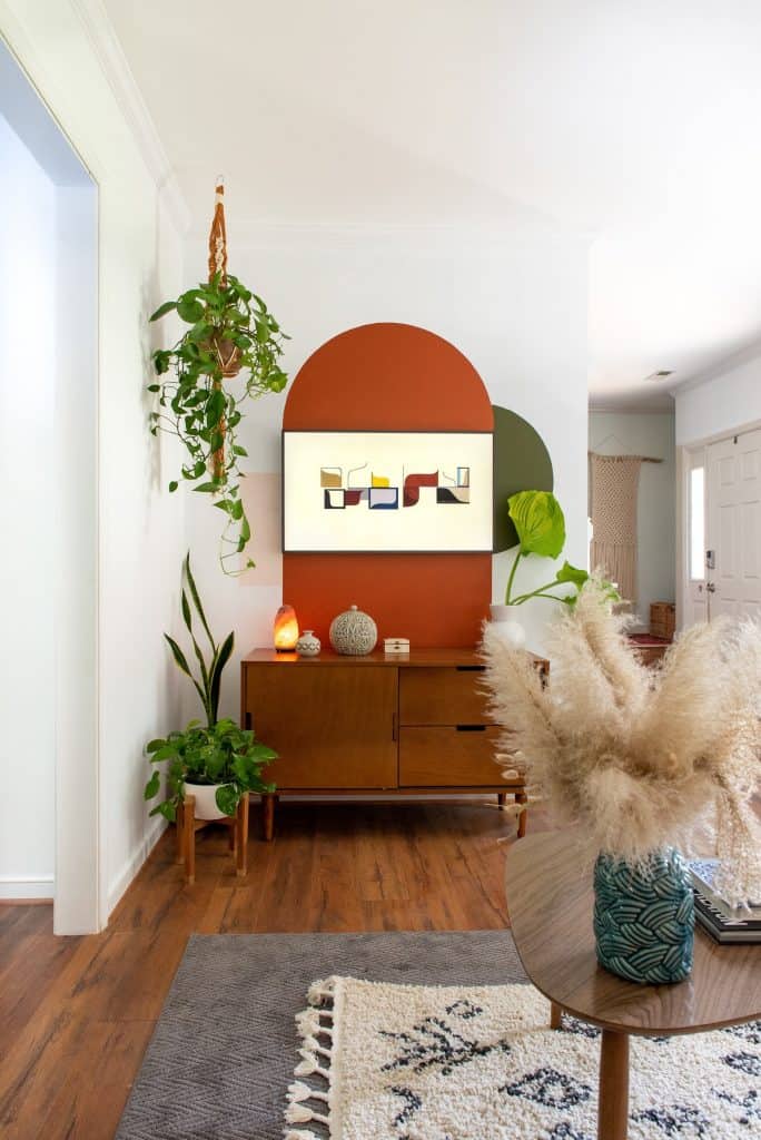 Orange painted arch around tv on a living room wall.