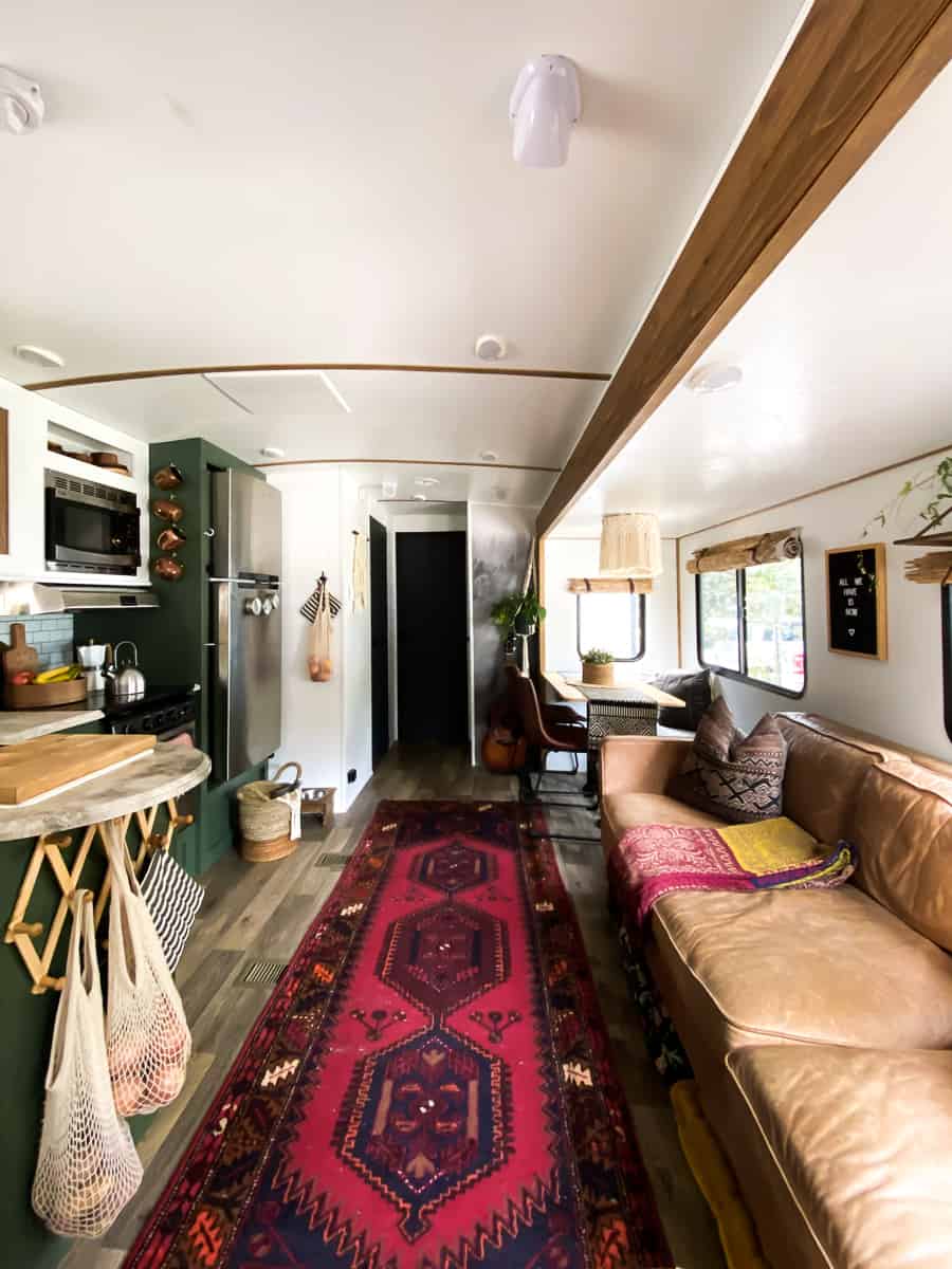 Vintage rug, leather sofa and bold colors in an eclectic camper.