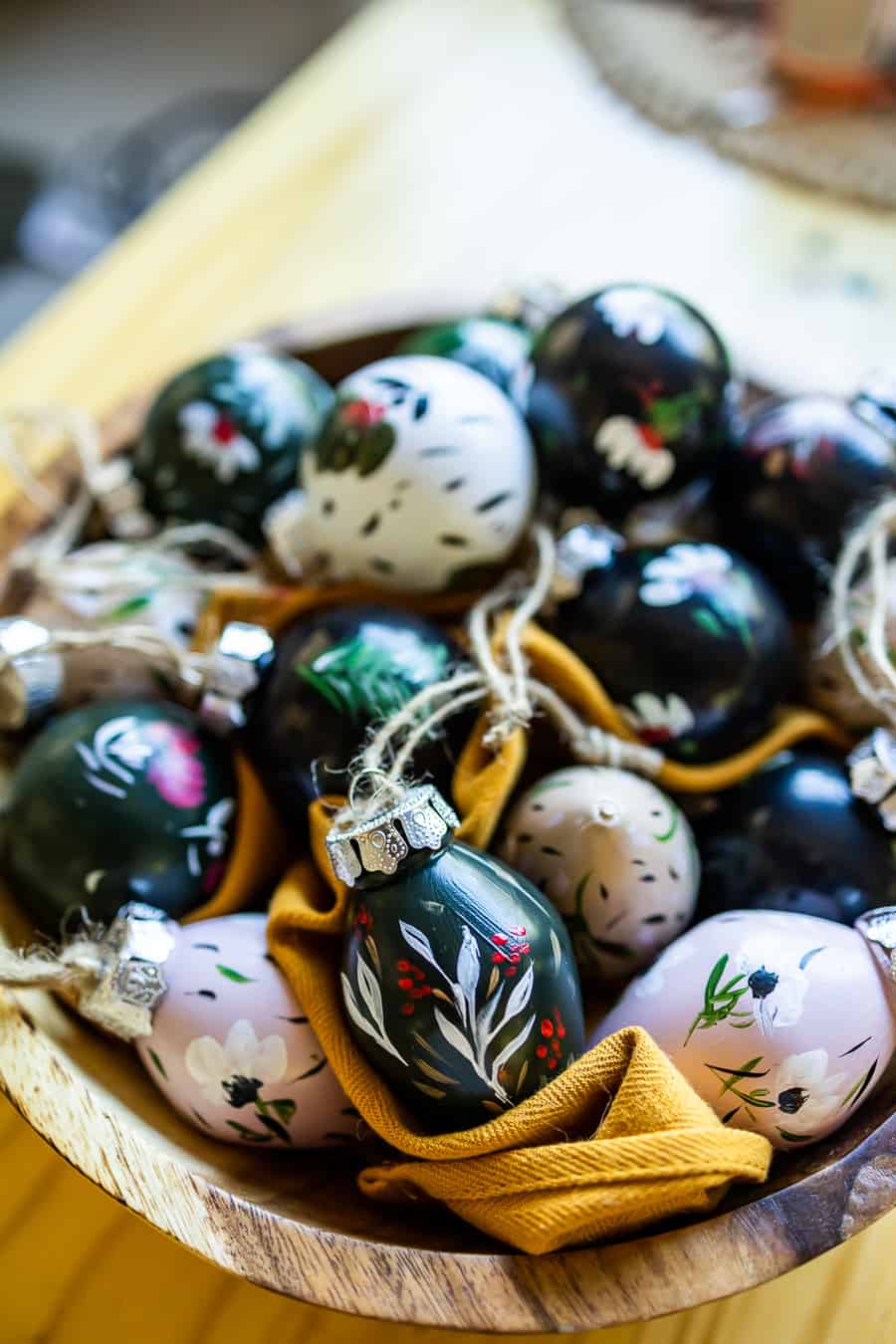 a bowl of hand painted Christmas ornaments