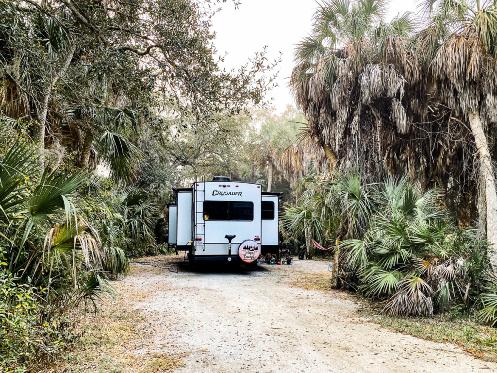 Crusader fifth wheel parked on campsite with palm trees