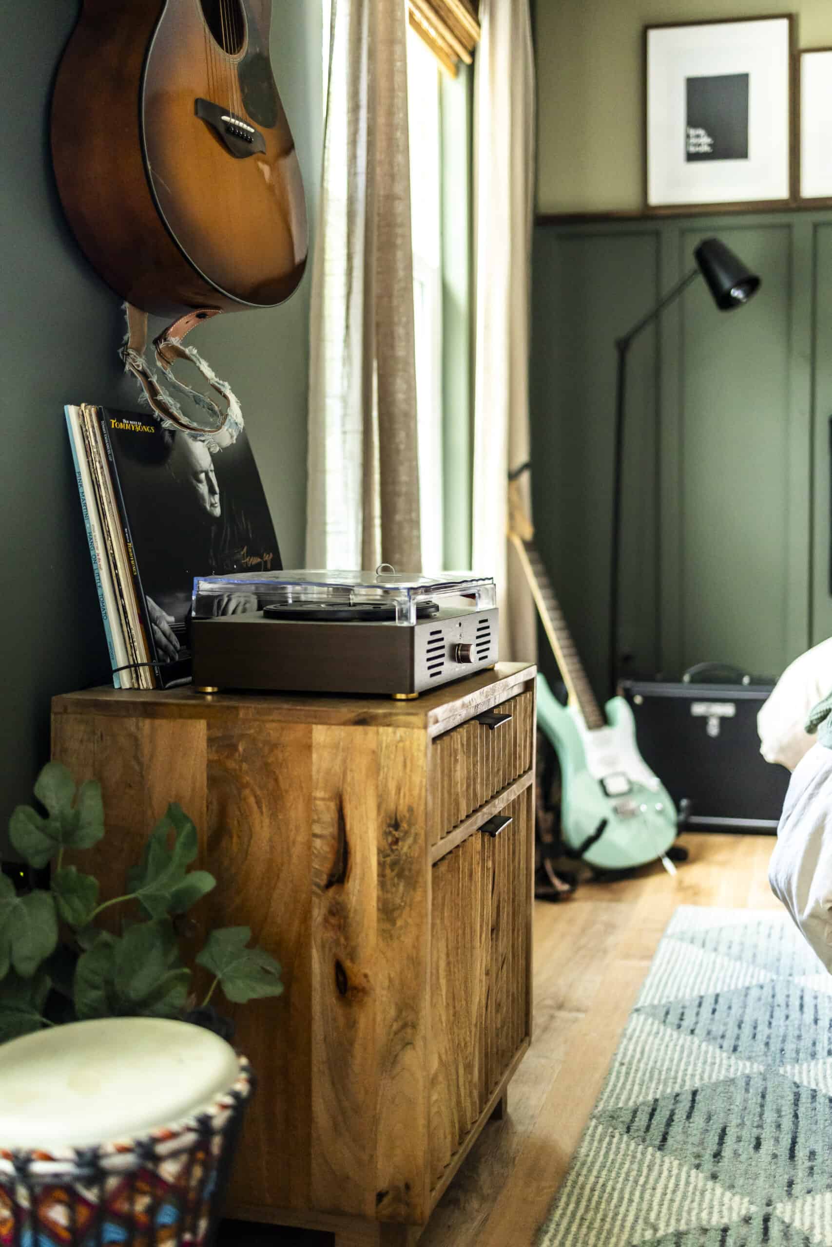 Wooden furniture and guitar displayed on the wall in teenage boy bedroom